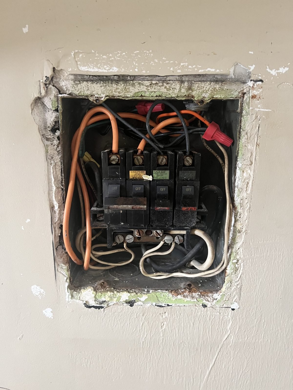 Old fuse box before: burnt, crowded wiring in a broken wall box