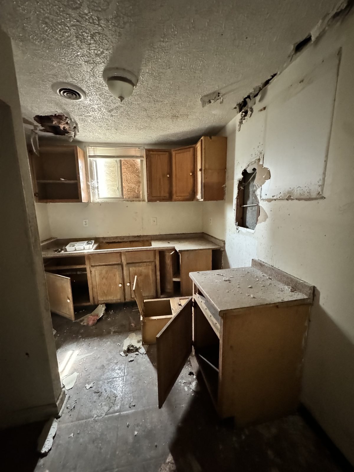 Kitchen before: collapsed ceiling, cabinets torn out