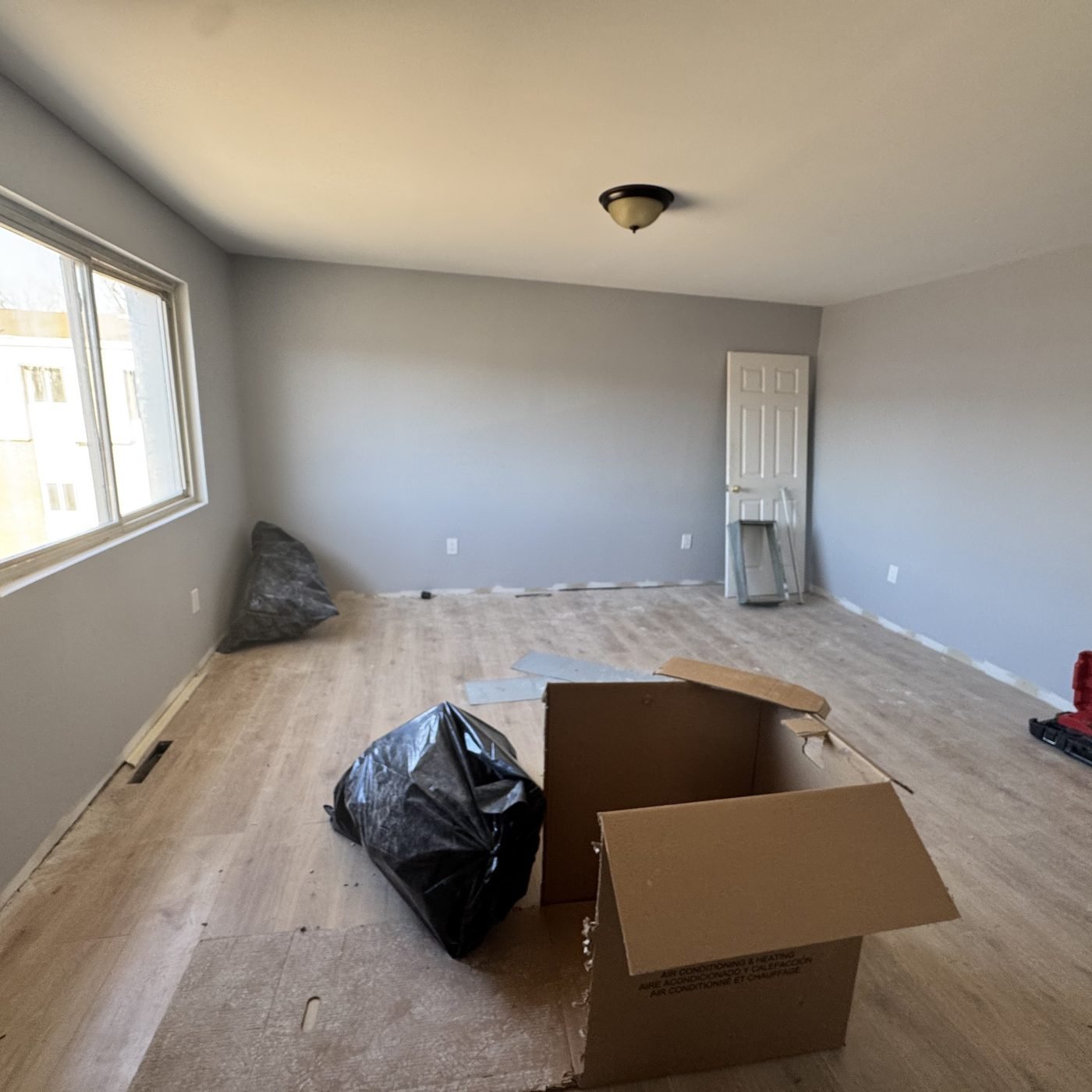 Bedroom after: new ceiling, paint and plank flooring